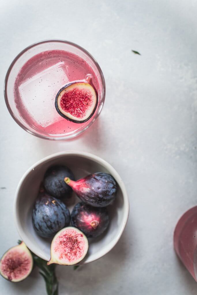 Fig cocktail next to bowl of figs.