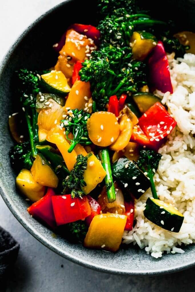 Veggie stir fry in bowl with chopsticks.