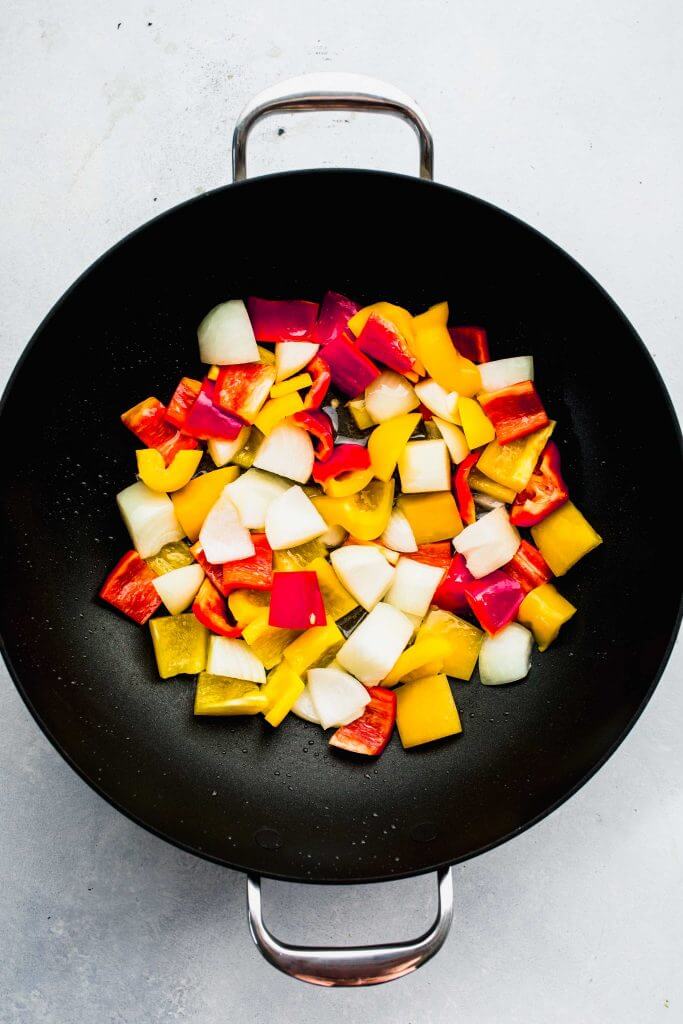Chopped onions and peppers in wok. 