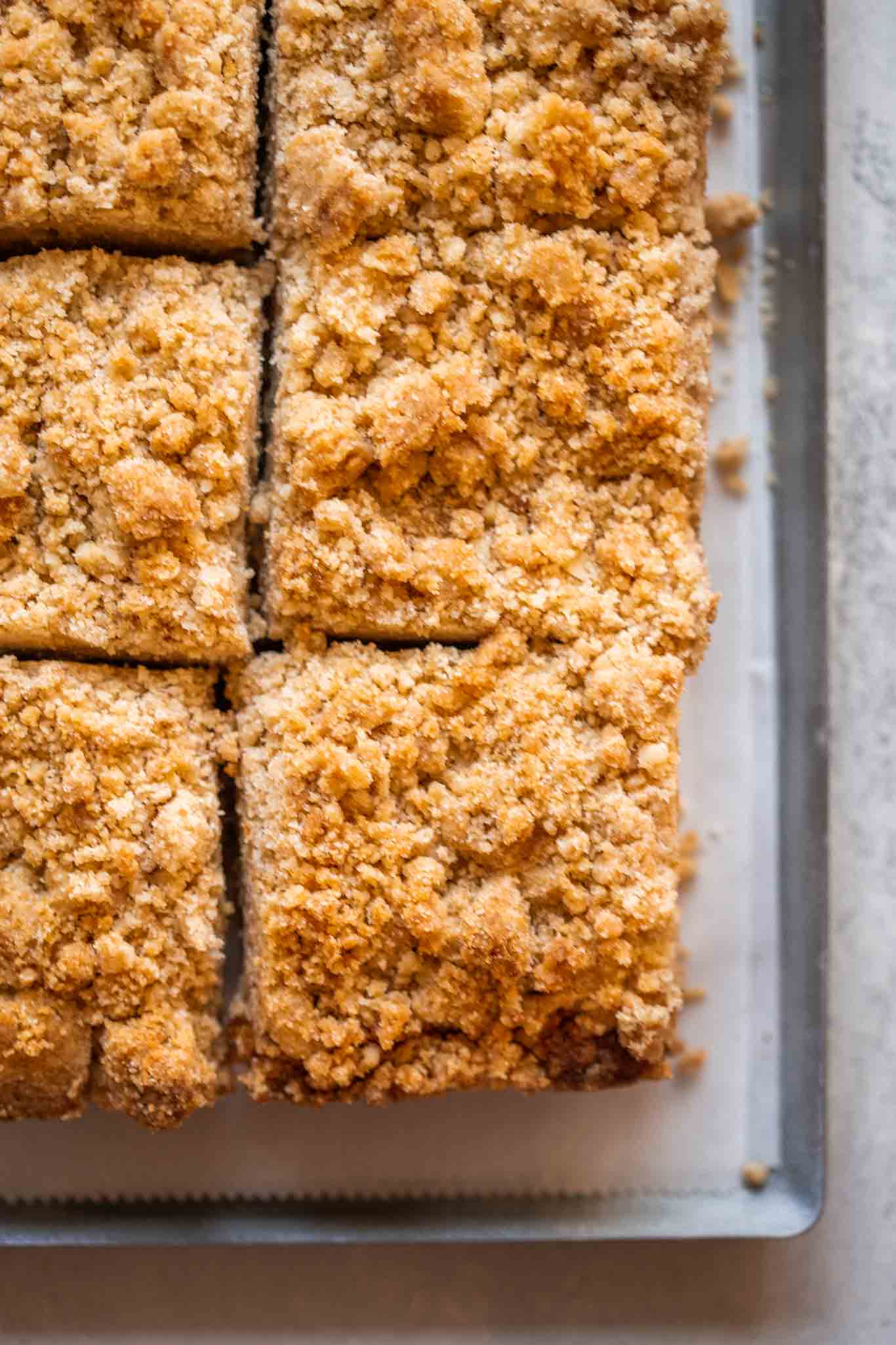 Overhead shot of coffee cake with yogurt in baking pan sliced into pieces. 