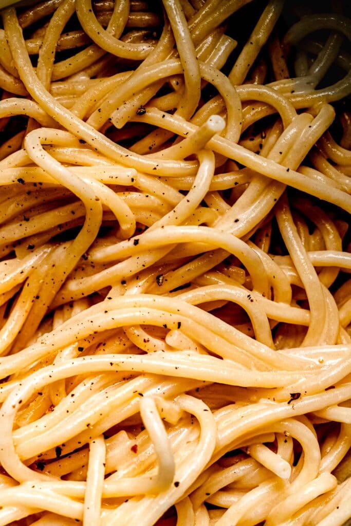 Extreme close up of pasta coated in creamy sauce. 