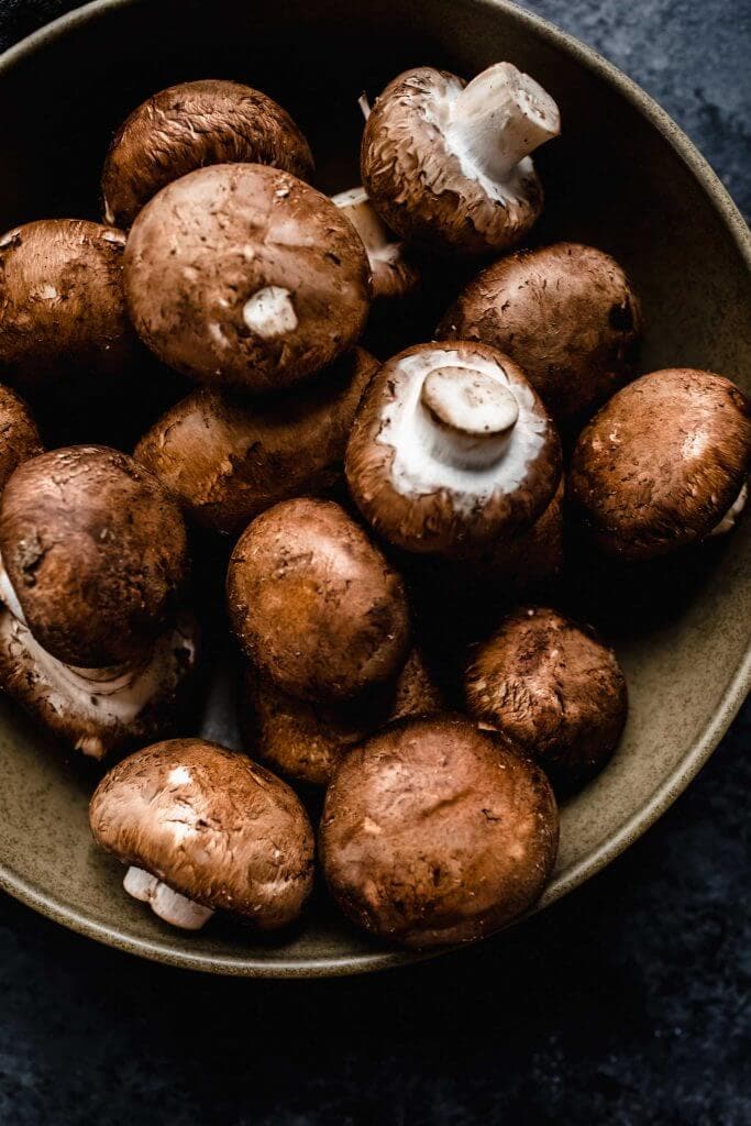 Close up of bowl of cremini mushrooms.