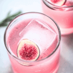 Two fig cocktails in glasses garnished with fresh figs.
