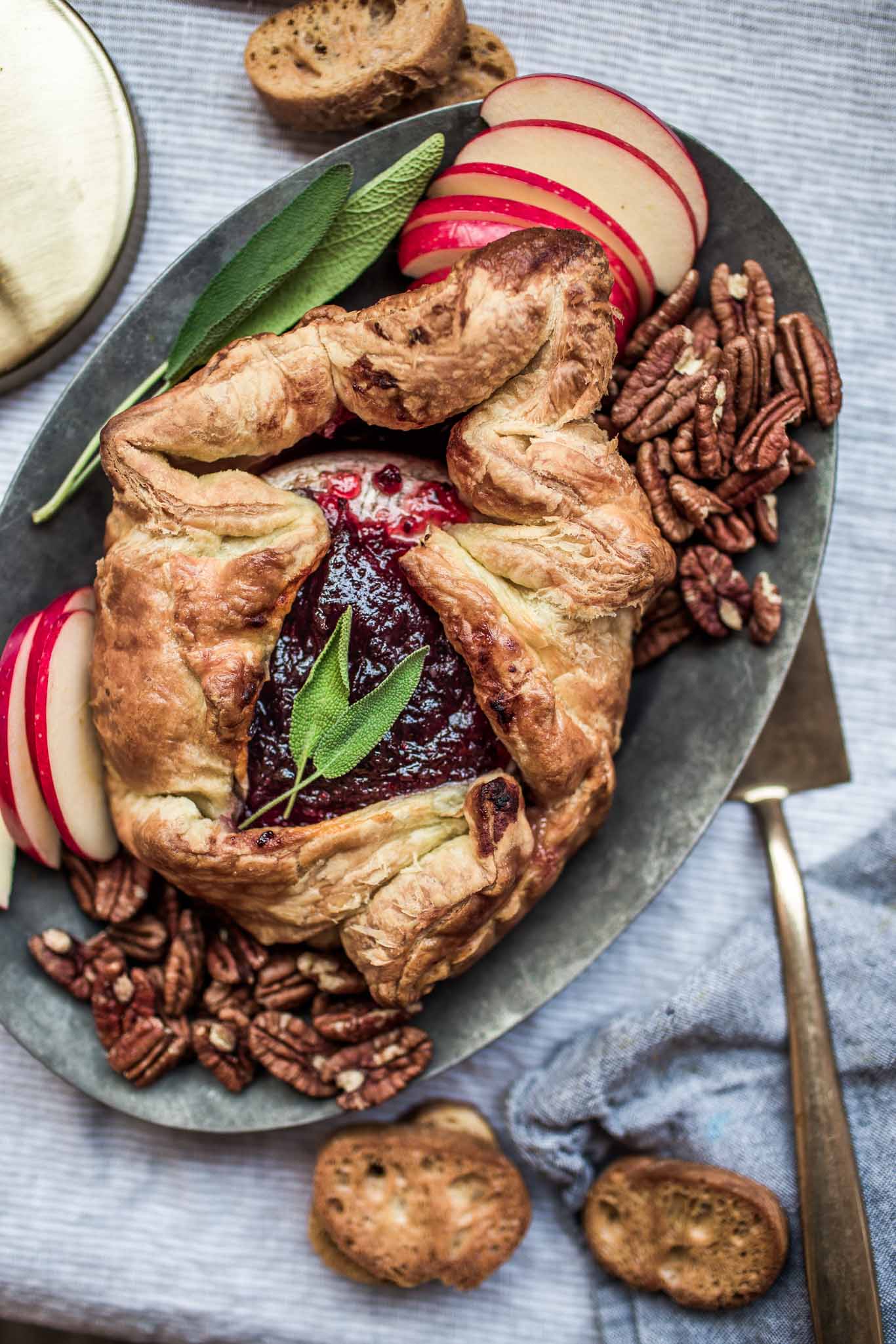 Overhead shot of baked brie in puff pastry with red currant fruit spread.