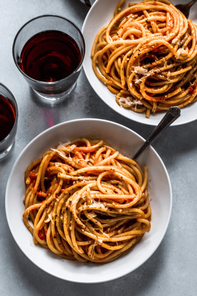 Two bowls of bucatini tossed with butter roasted tomato sauce. 