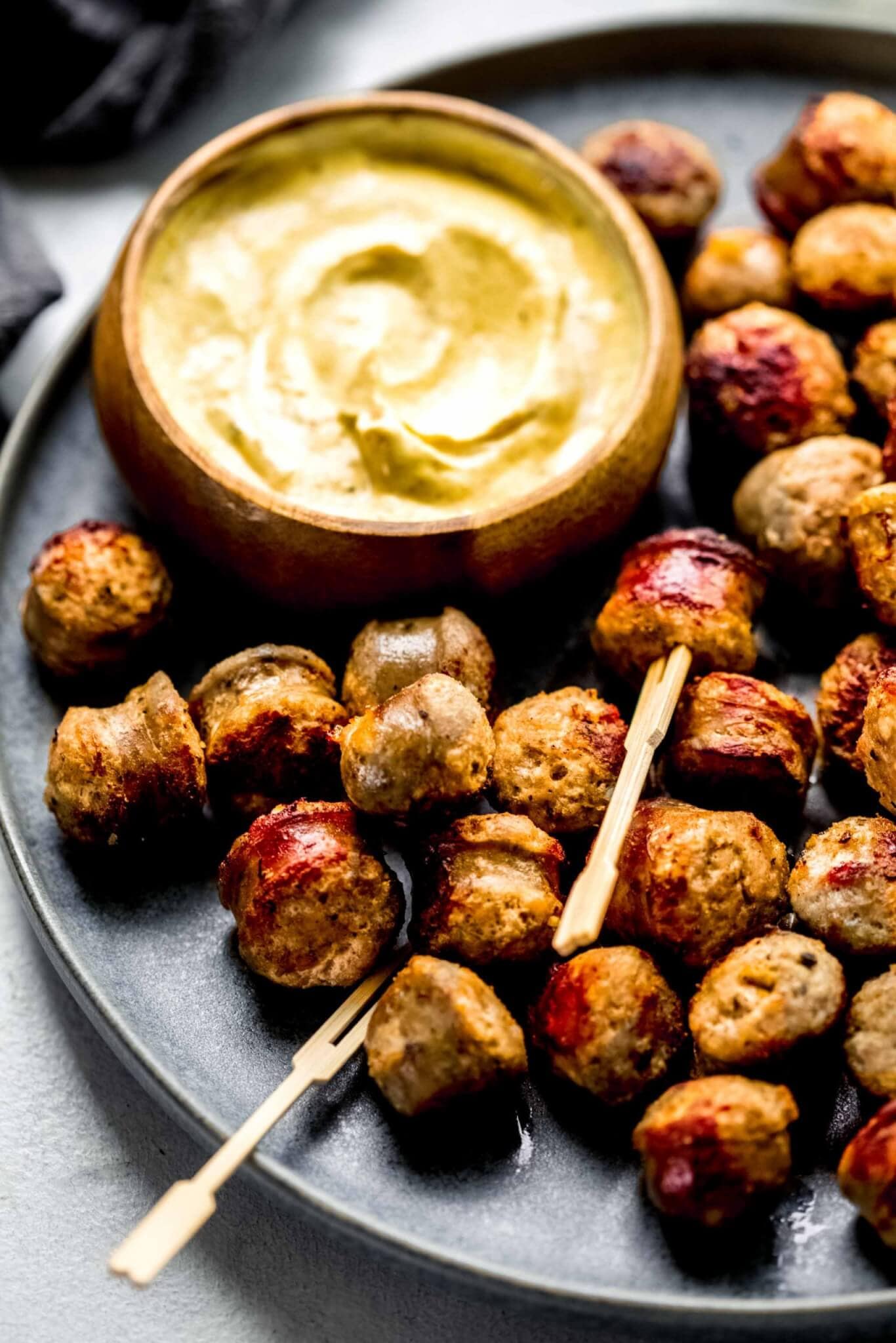 Side view of sausage bites on grey plate. 