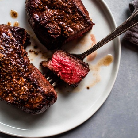 Overhead shot of cooked filet mignon with slice taken.