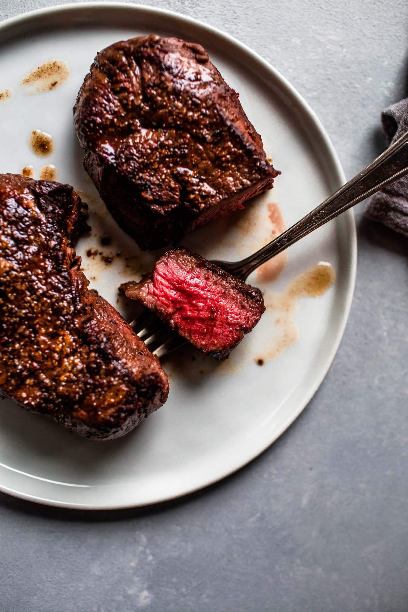 Overhead shot of cooked filet mignon with slice taken.