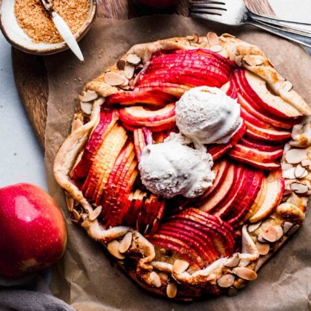 APPLE GALETTE ON WOODEN BOARD TOPPED WITH ICE CREAM.