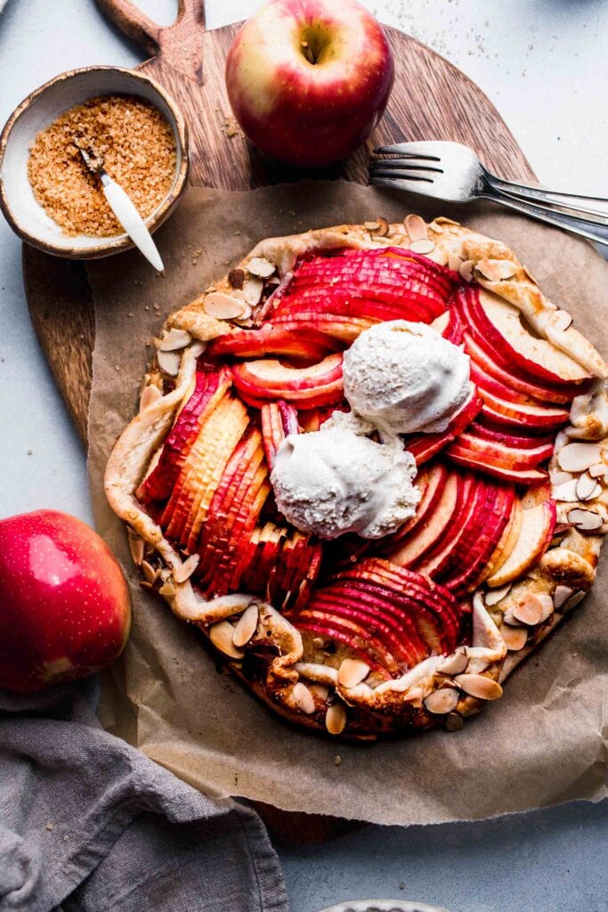 APPLE GALETTE ON WOODEN BOARD TOPPED WITH ICE CREAM.