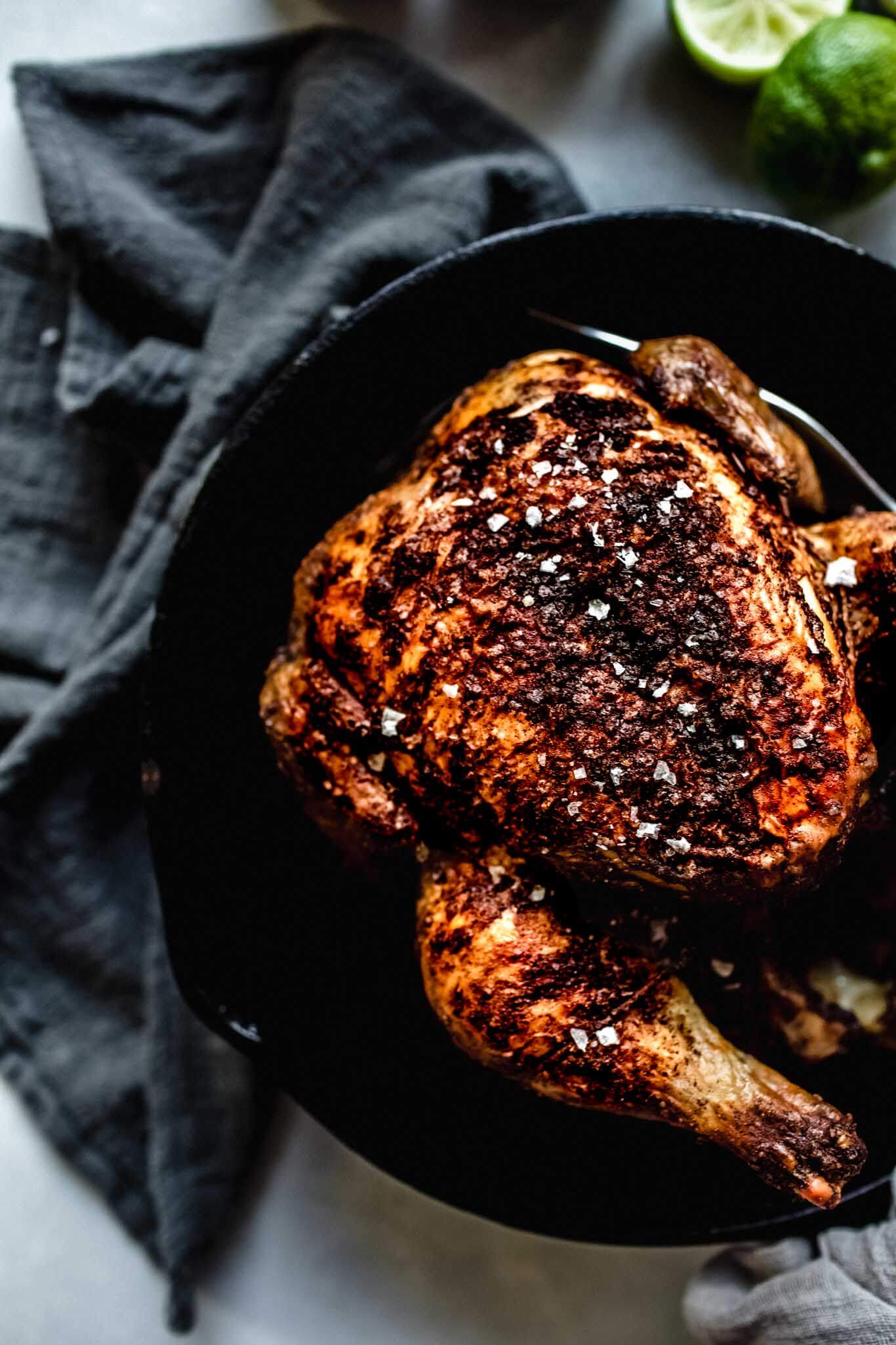 Overhead close up shot of chicken in cast iron skillet.