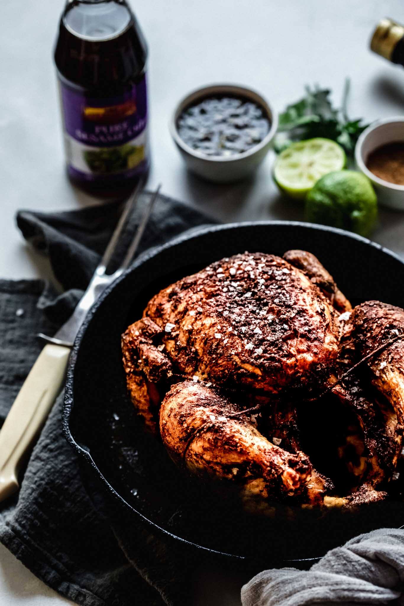 Side view of chicken in cast iron skillet.