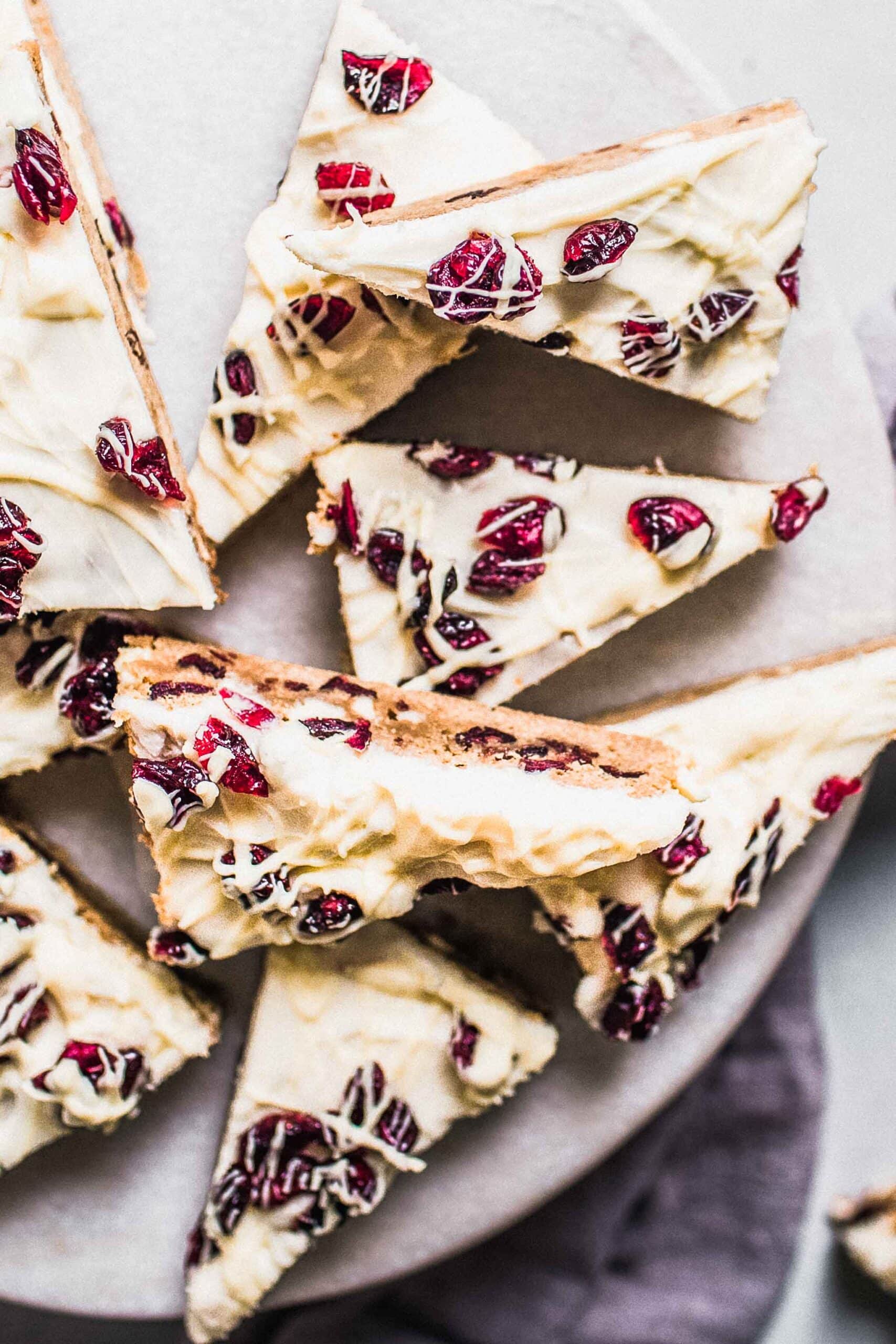 Cranberry bliss bars arranged on white serving platter.