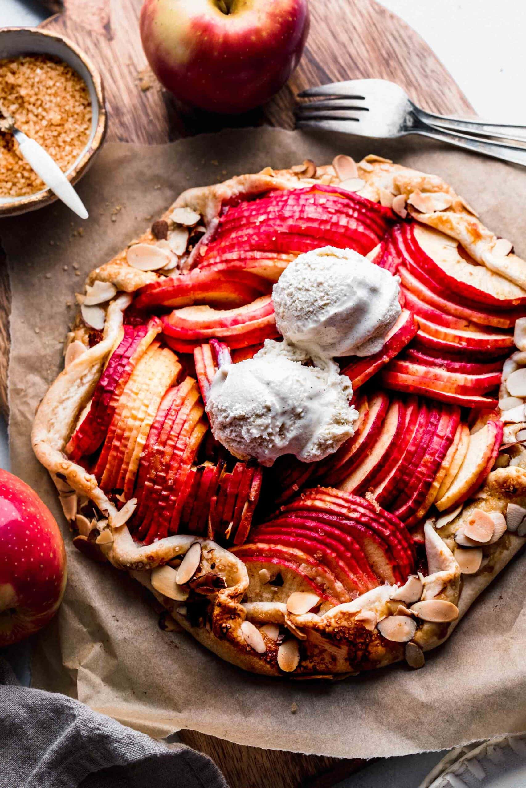 APPLE GALETTE ON WOODEN BOARD TOPPED WITH ICE CREAM.