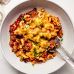 Instant pot chili mac in white bowl with two forks.