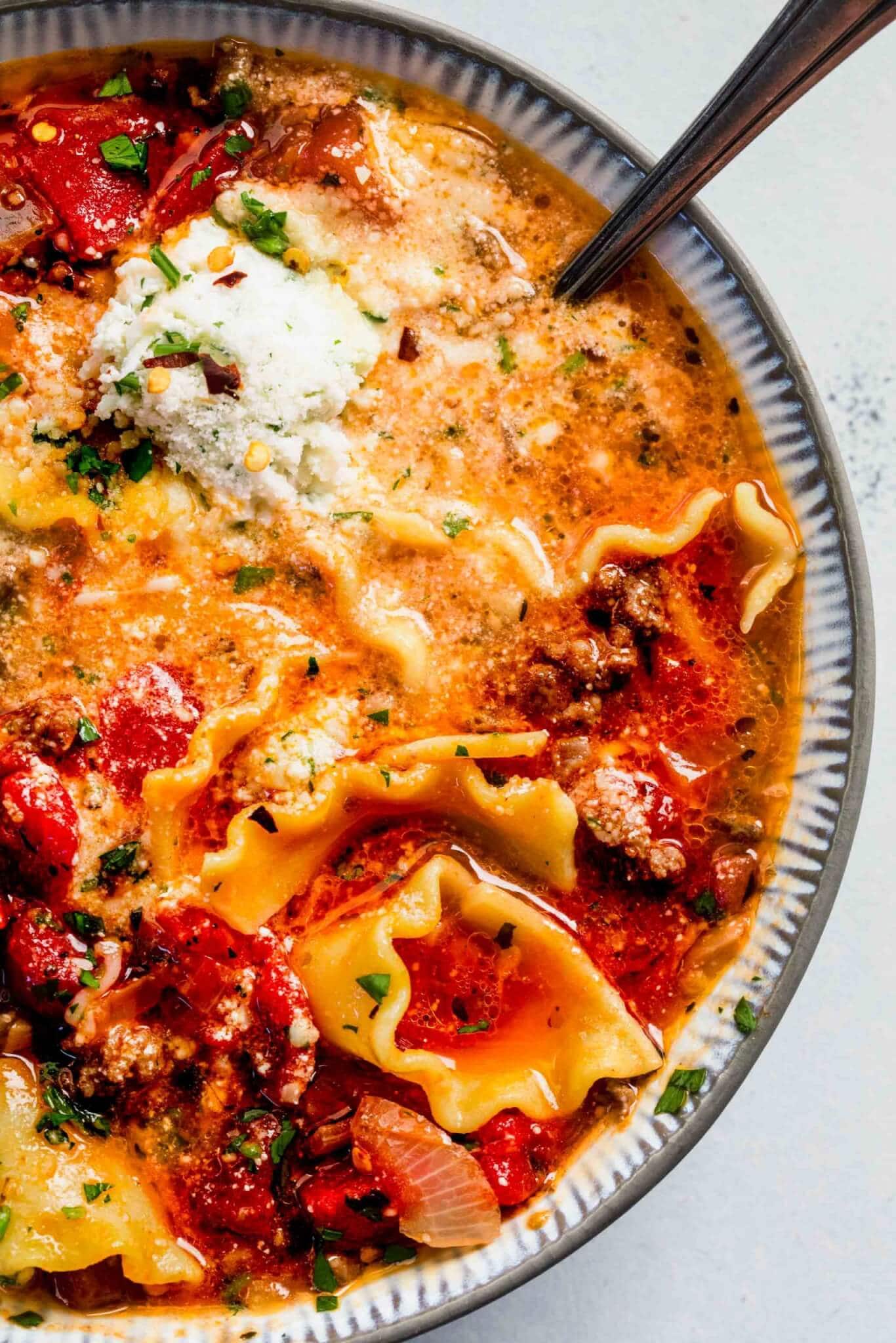 Close up of bowl of lasagna soup with spoon. 