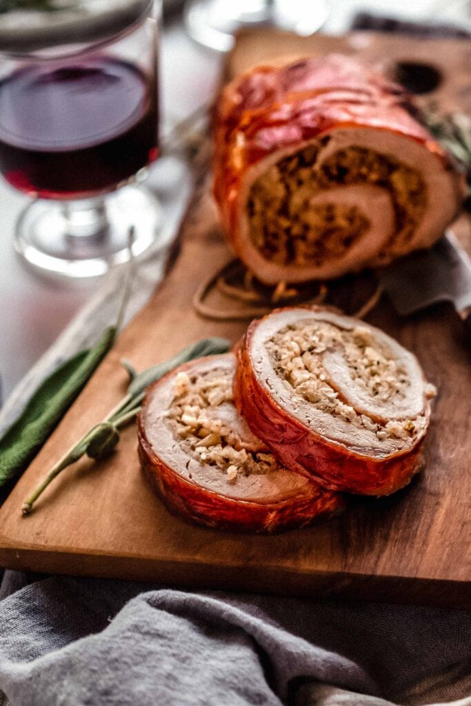 Prosciutto wrapped pork tenderloin sliced in pieces so that you can see the stuffing filling.