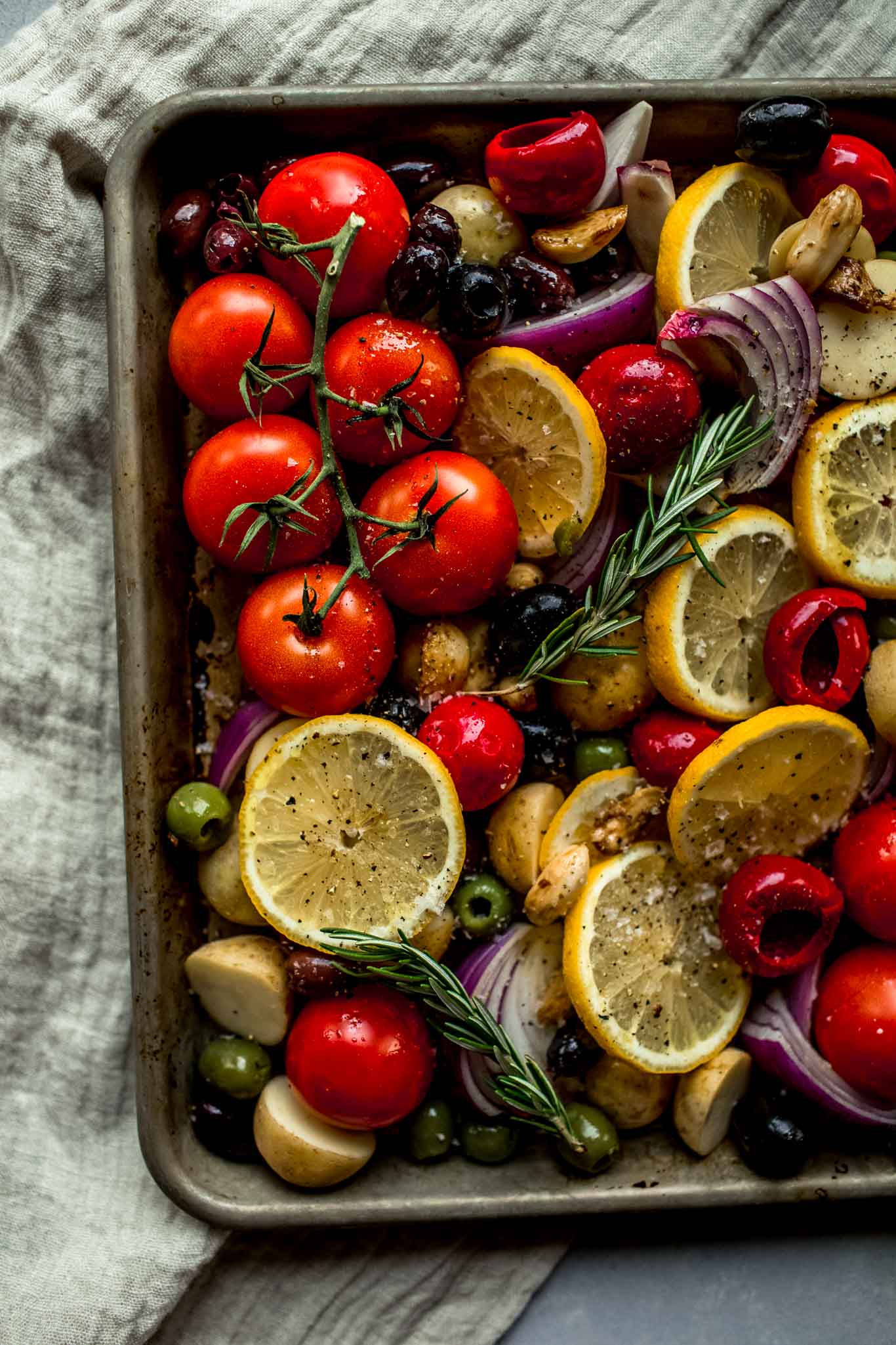 Veggies and olives arranged on sheet pan.