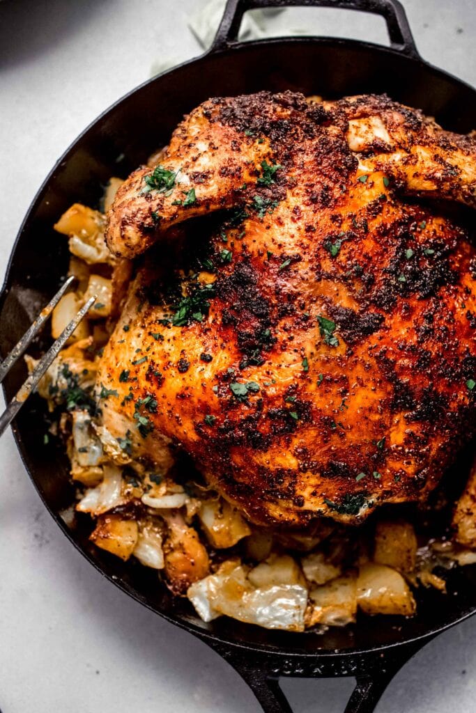 Roasted spatchcock chicken in skillet with potatoes and cabbage. 