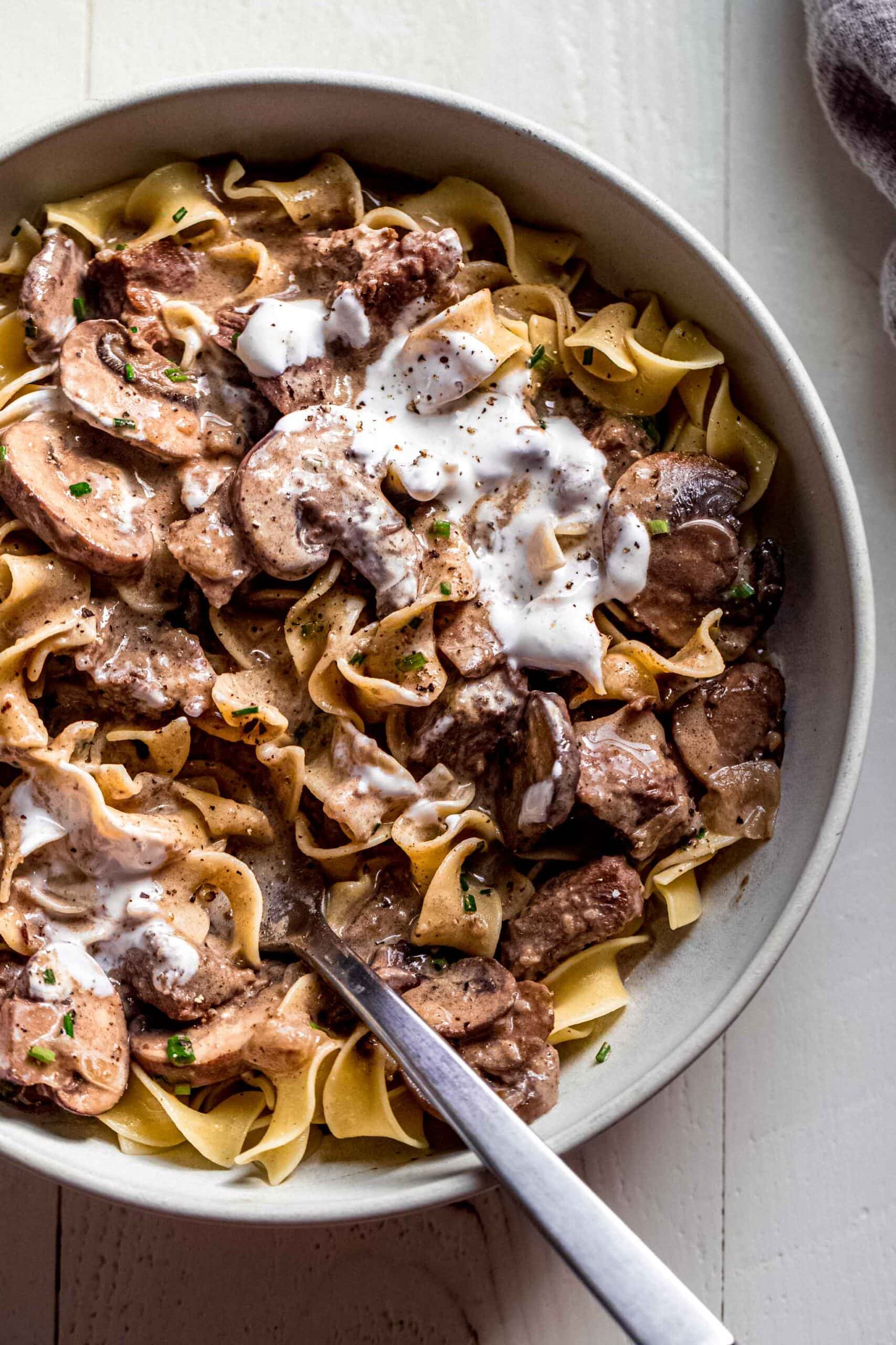 Beef Stroganoff in white bowl with spoon.