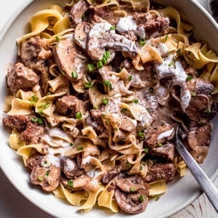 Overhead shot of stroganoff in serving bowl topped with chives.