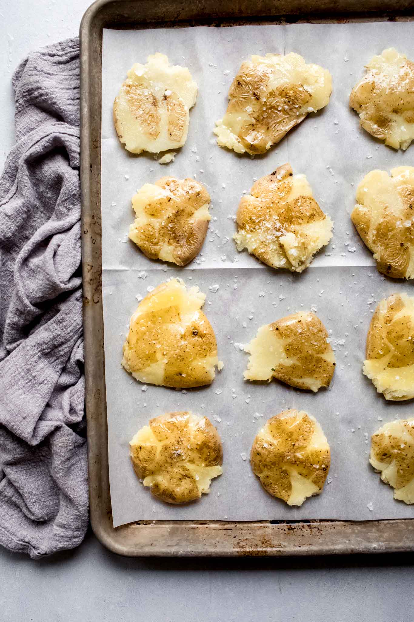 Smashed potatoes on baking sheet before going into oven.