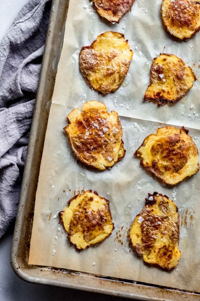 Cooked crispy smashed potatoes on baking sheet.
