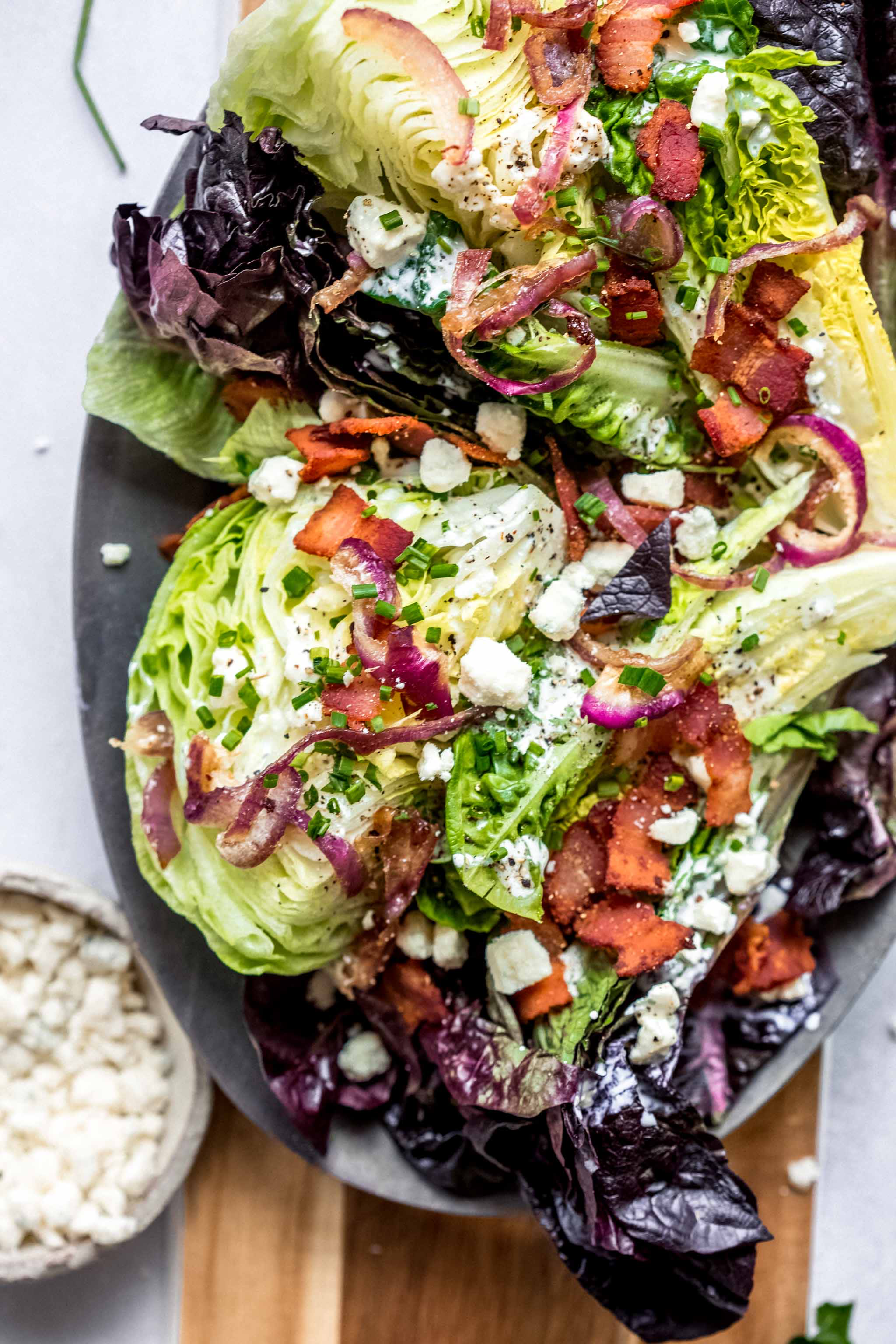 This Healthy Wedge Salad is topped with a lower-calorie tangy buttermilk-blue cheese dressing and combines iceberg lettuce with radicchio and romaine. It’s topped with crispy onions and bacon for added crunch.