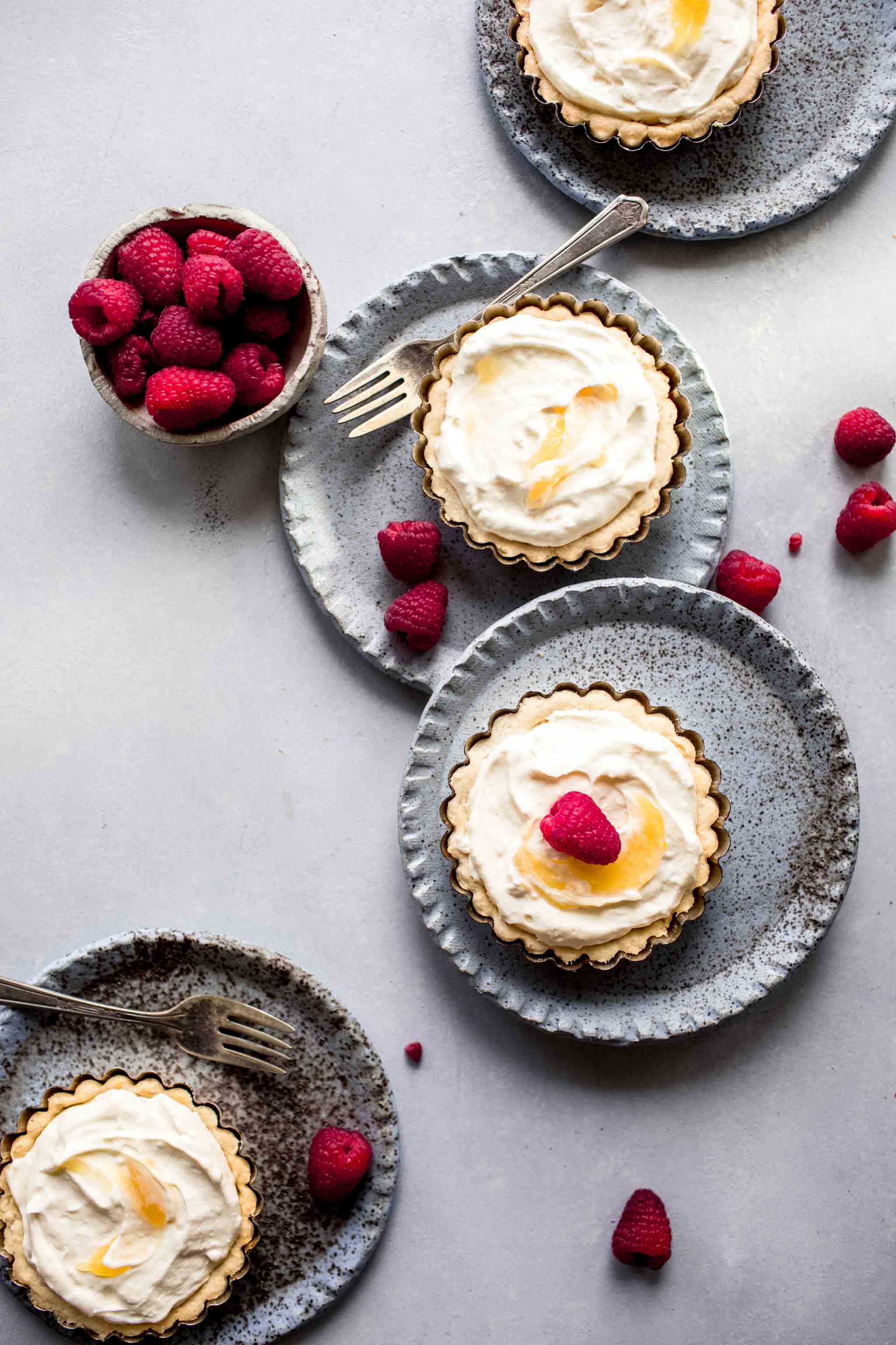 These Lemon Tartlets are the most delicious dessert. A delicate buttery crust is topped with a lemon curd-cream cheese blend that tastes like cheesecake. Top them off with raspberries to make them even more pretty and delicious!