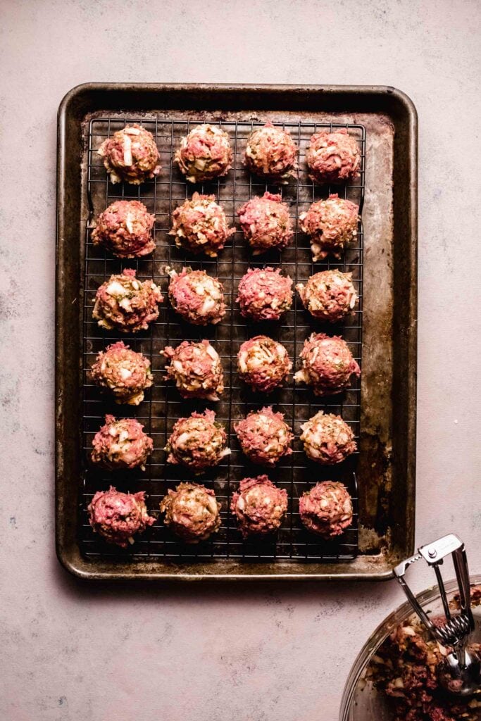 Formed meatballs on baking sheet. 