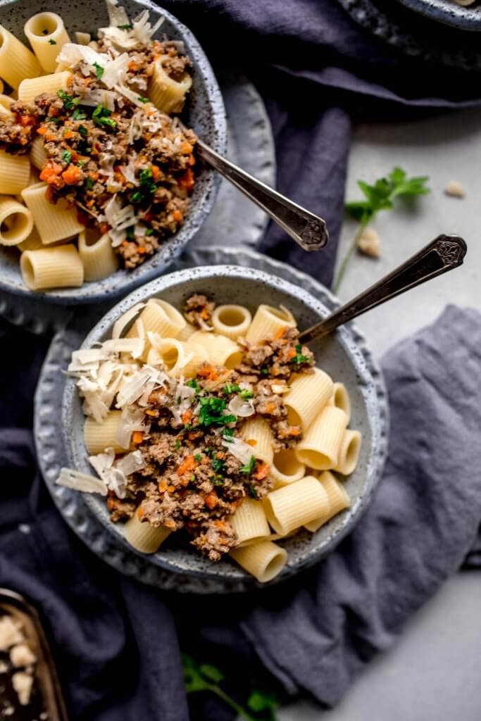 Two bowls of pasta with white bolognese.