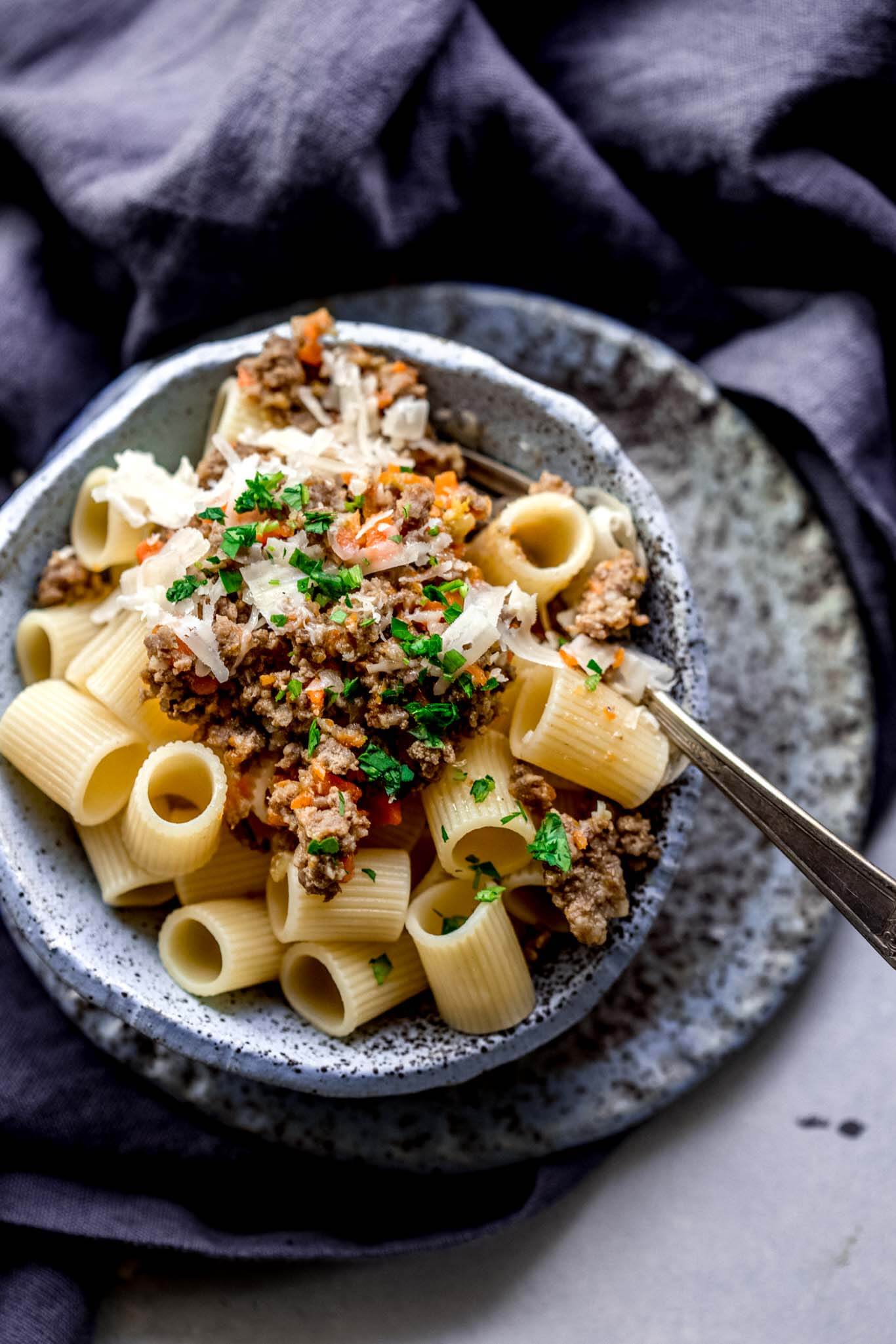 Close up of bowl of pasta with white bolognese sauce.