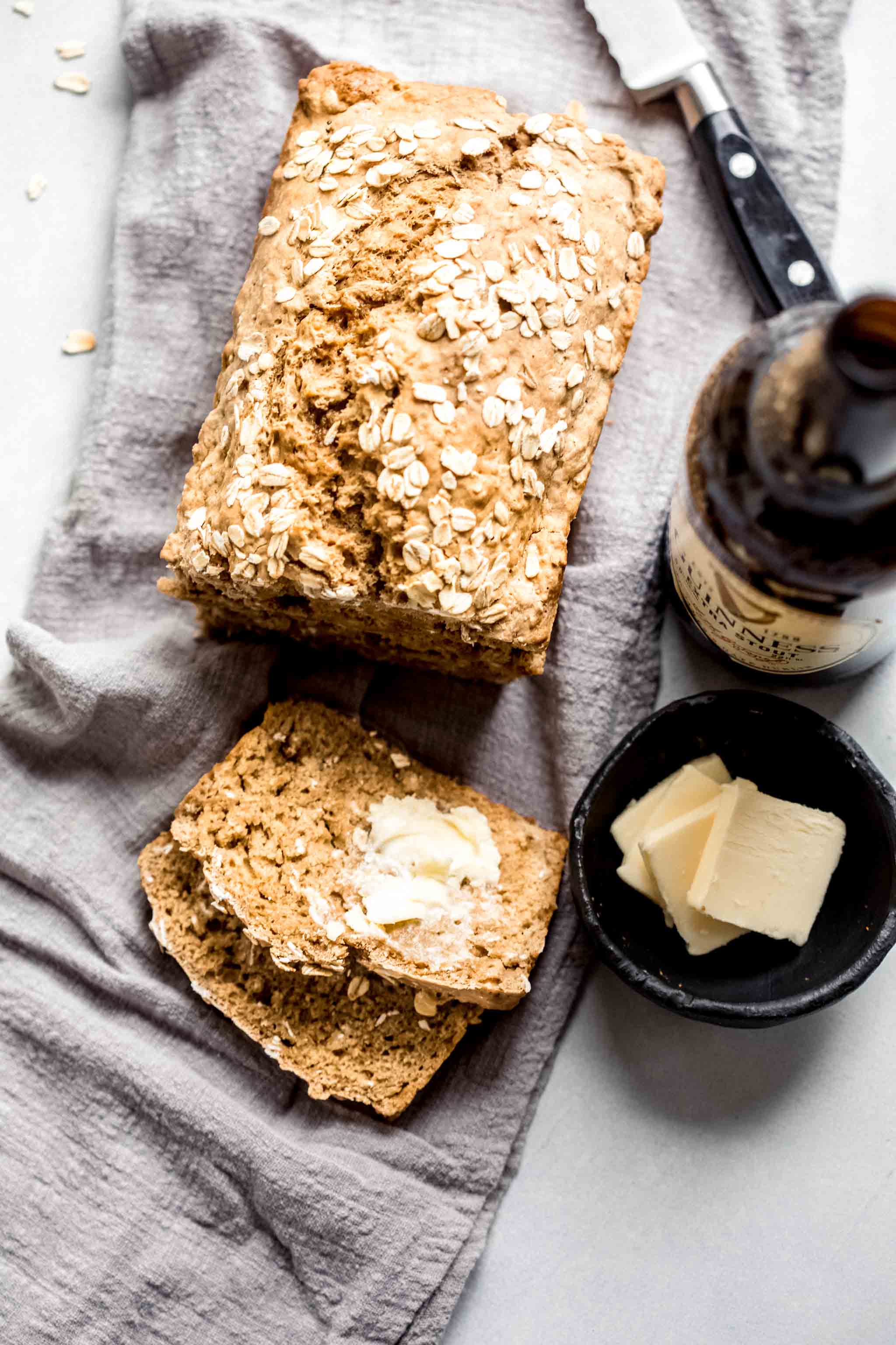 Overhead shot of guinness bread next to bottle of beer and pats of butter.