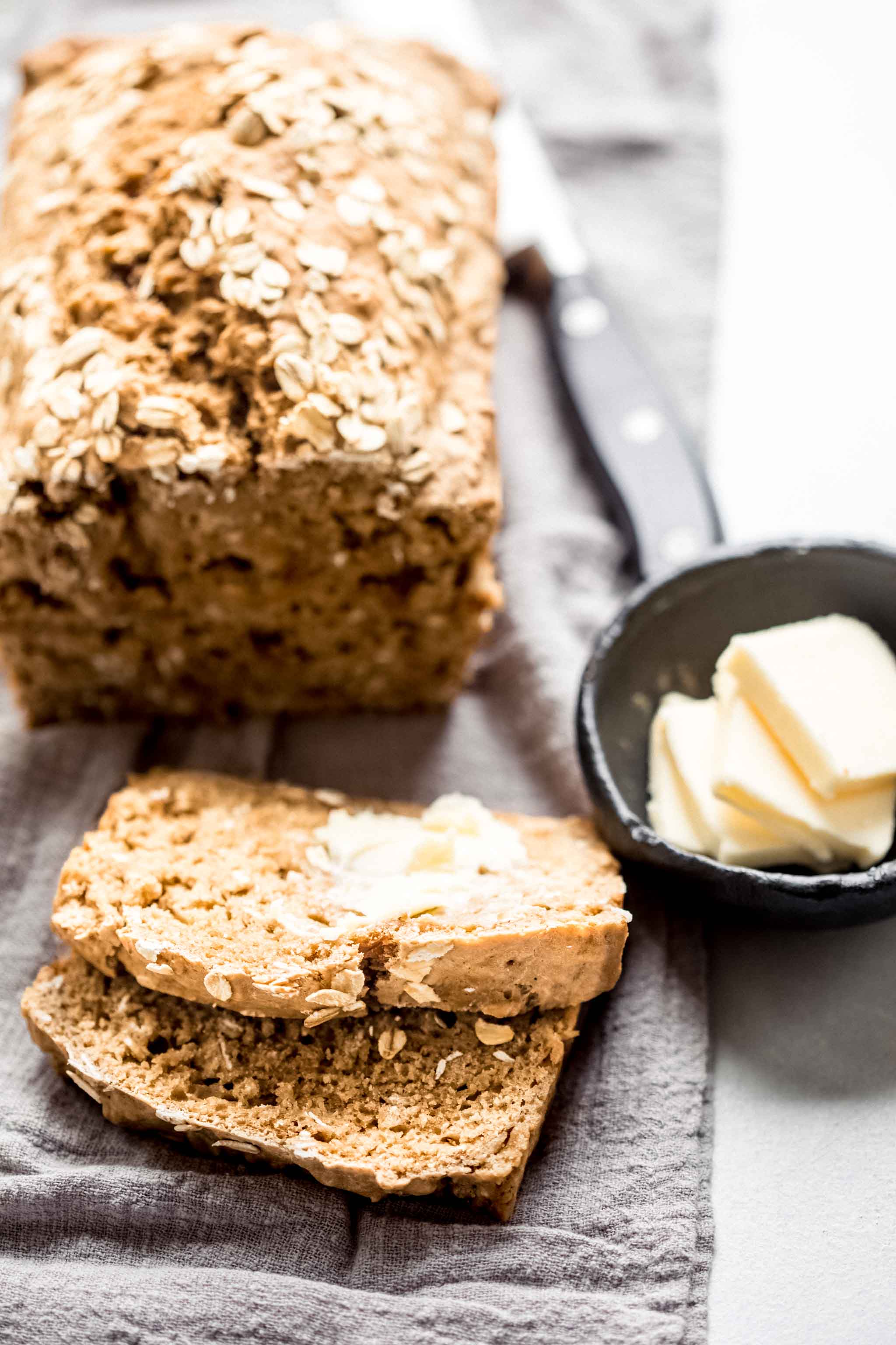 Side view of sliced guinness bread spread with butter. 