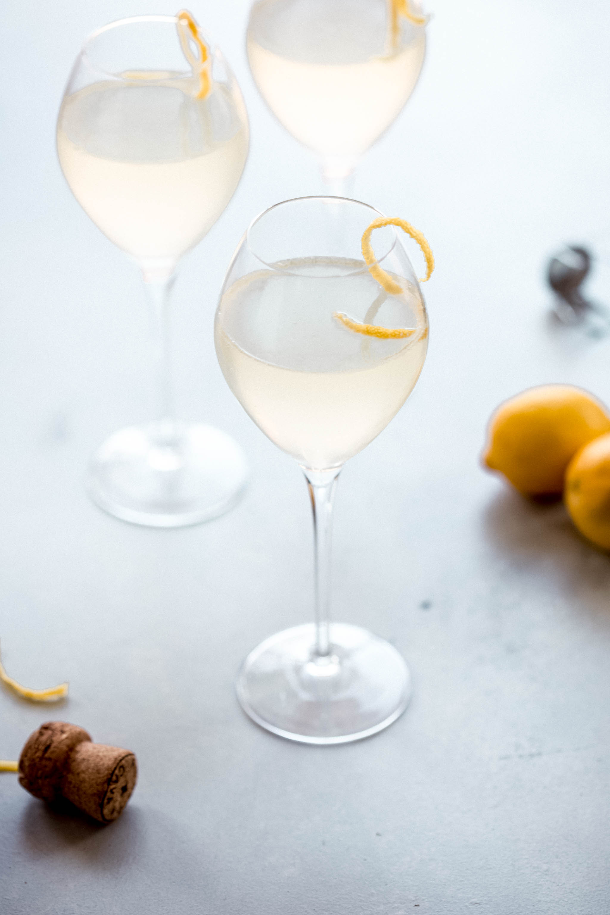 Side view of French 75 cocktail garnished with lemon twist.