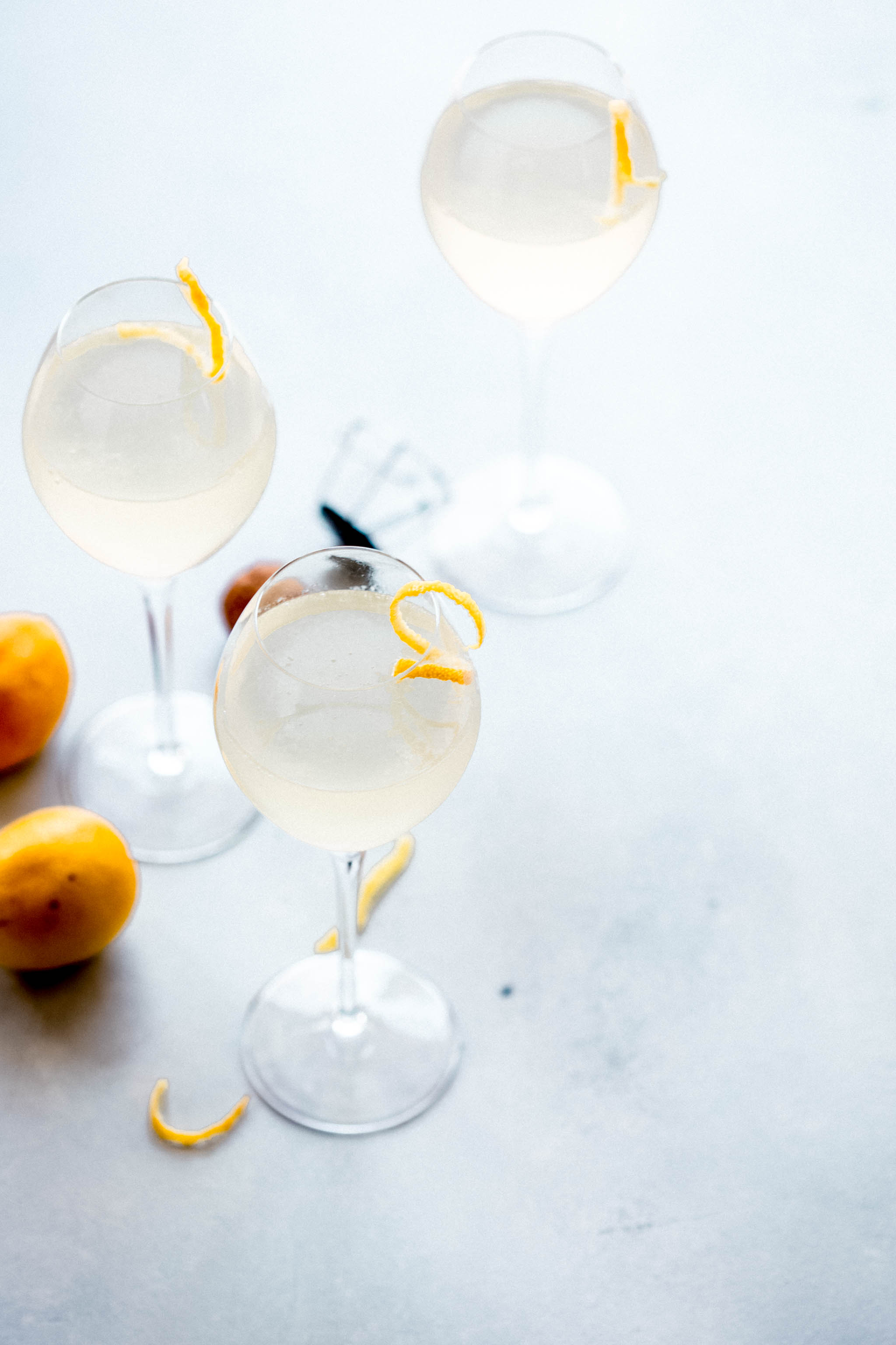 Three French 75 cocktails garnished with lemon twists.