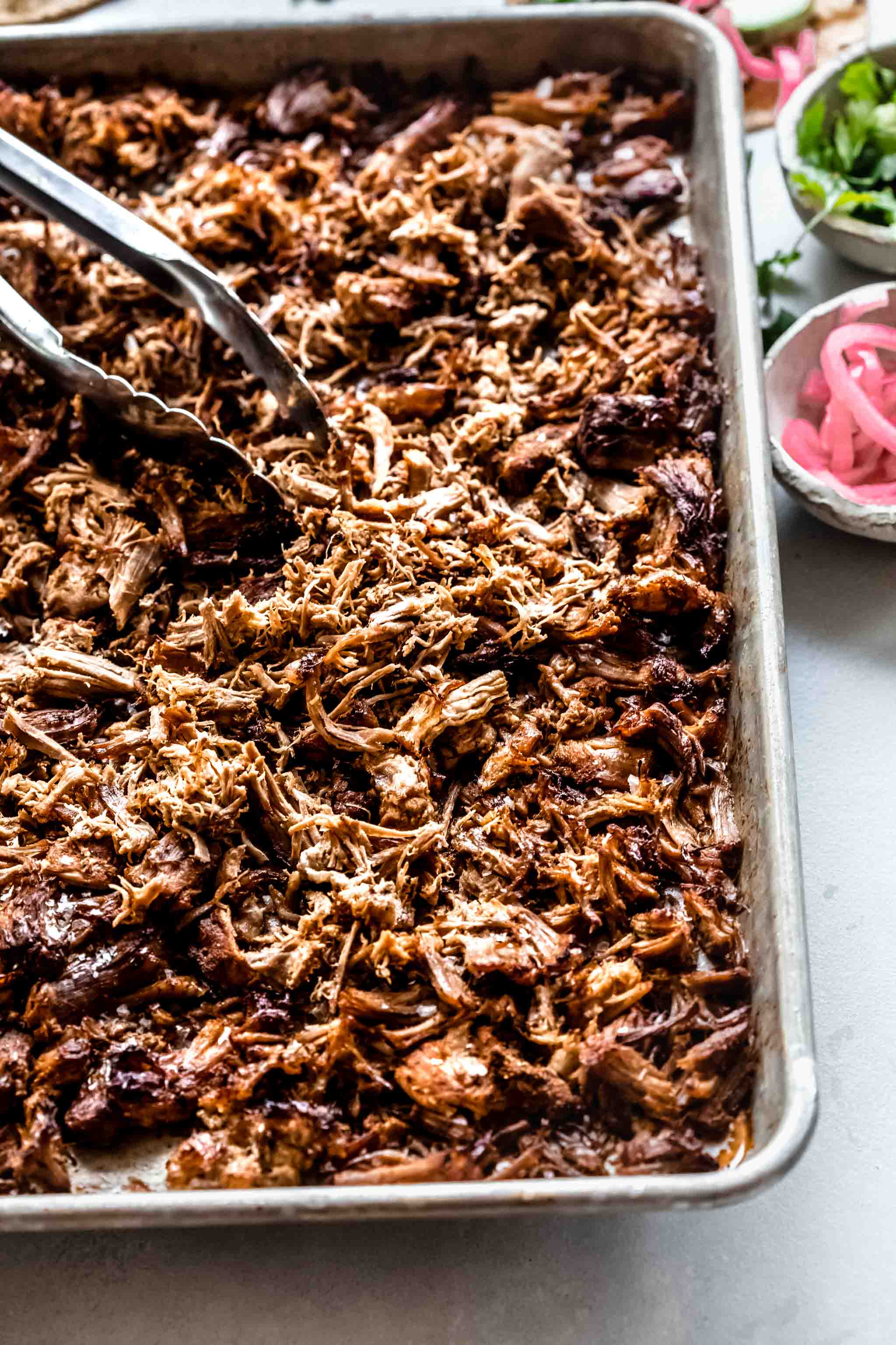 Carnitas on baking sheet after broiling in oven.