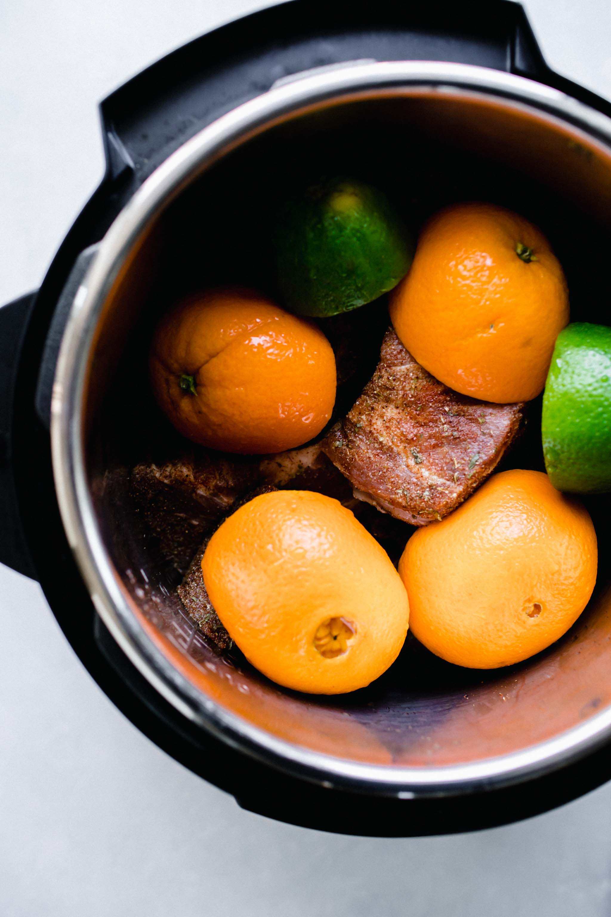 Oranges, limes and pork in Instant Pot.