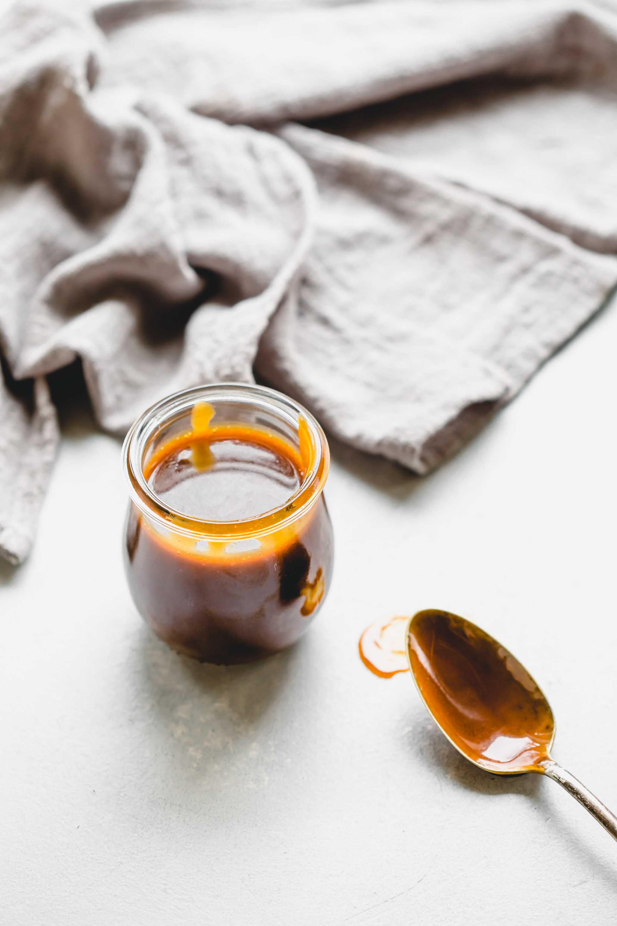 Salted Caramel Sauce in jar with spoon. 