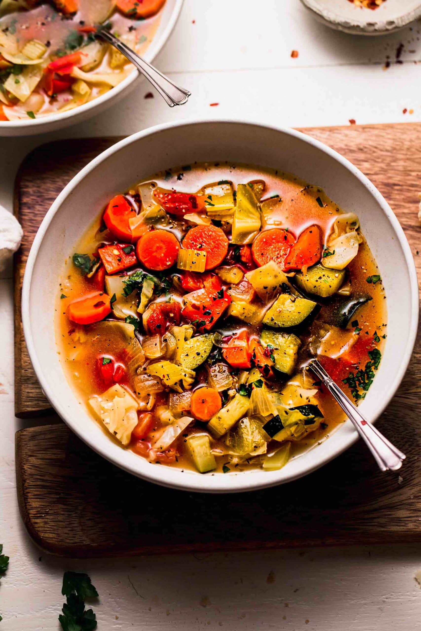 Overhead shot of bowl of weight loss soup on wood cutting board.