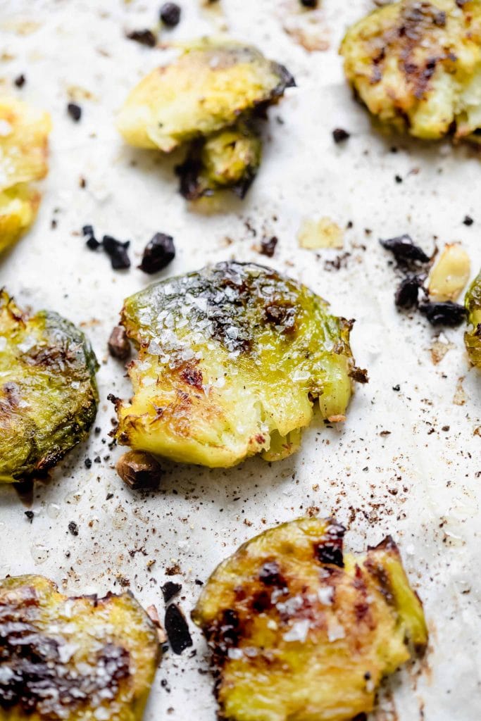 Crispy roasted and smashed brussel sprout on baking sheet. 