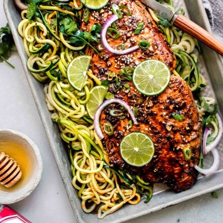 Overhead shot of salmon on baking sheet with zoodles.