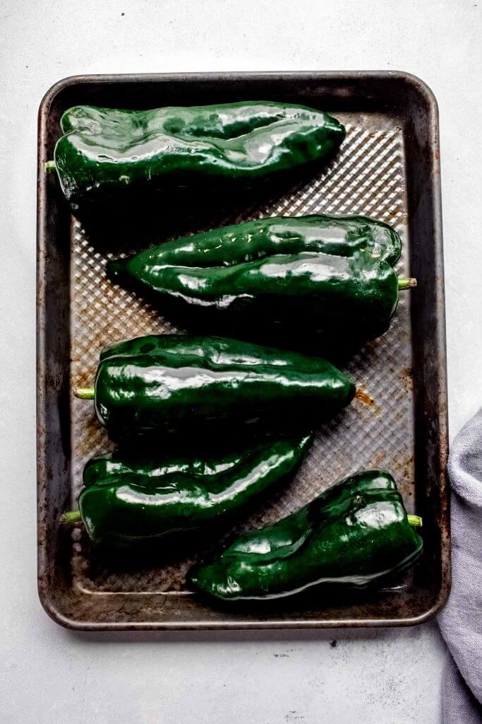 Poblanos arranged on baking sheet.