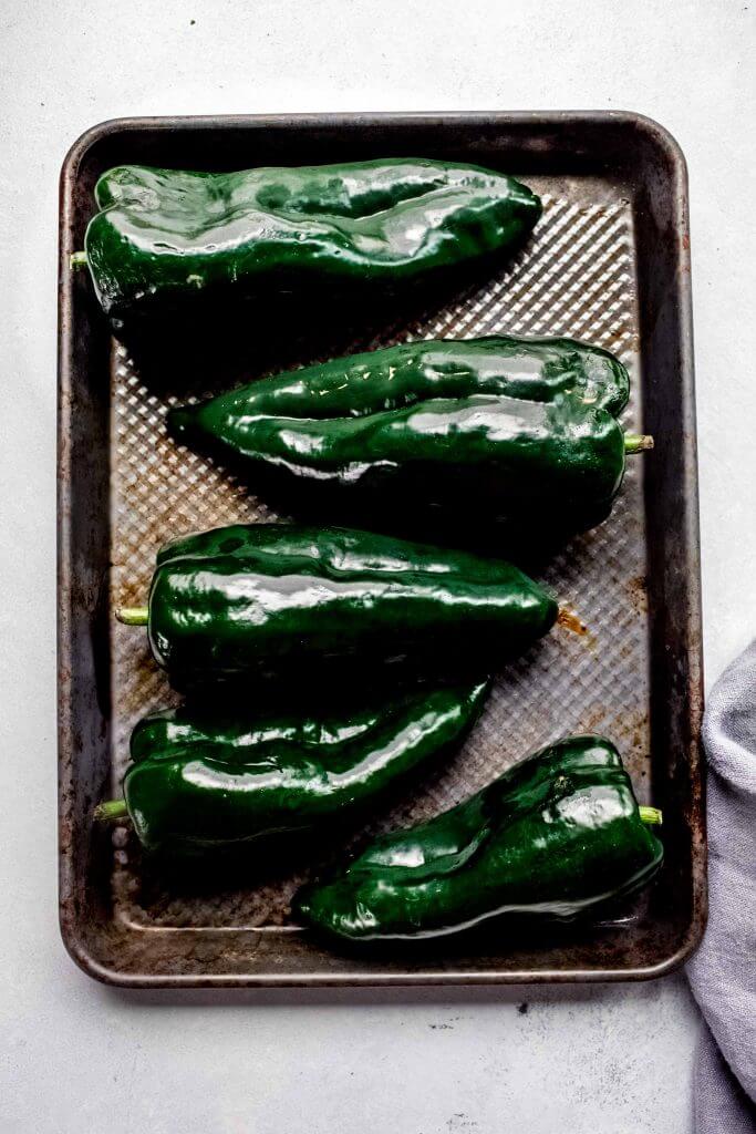 Poblanos arranged on baking sheet. 