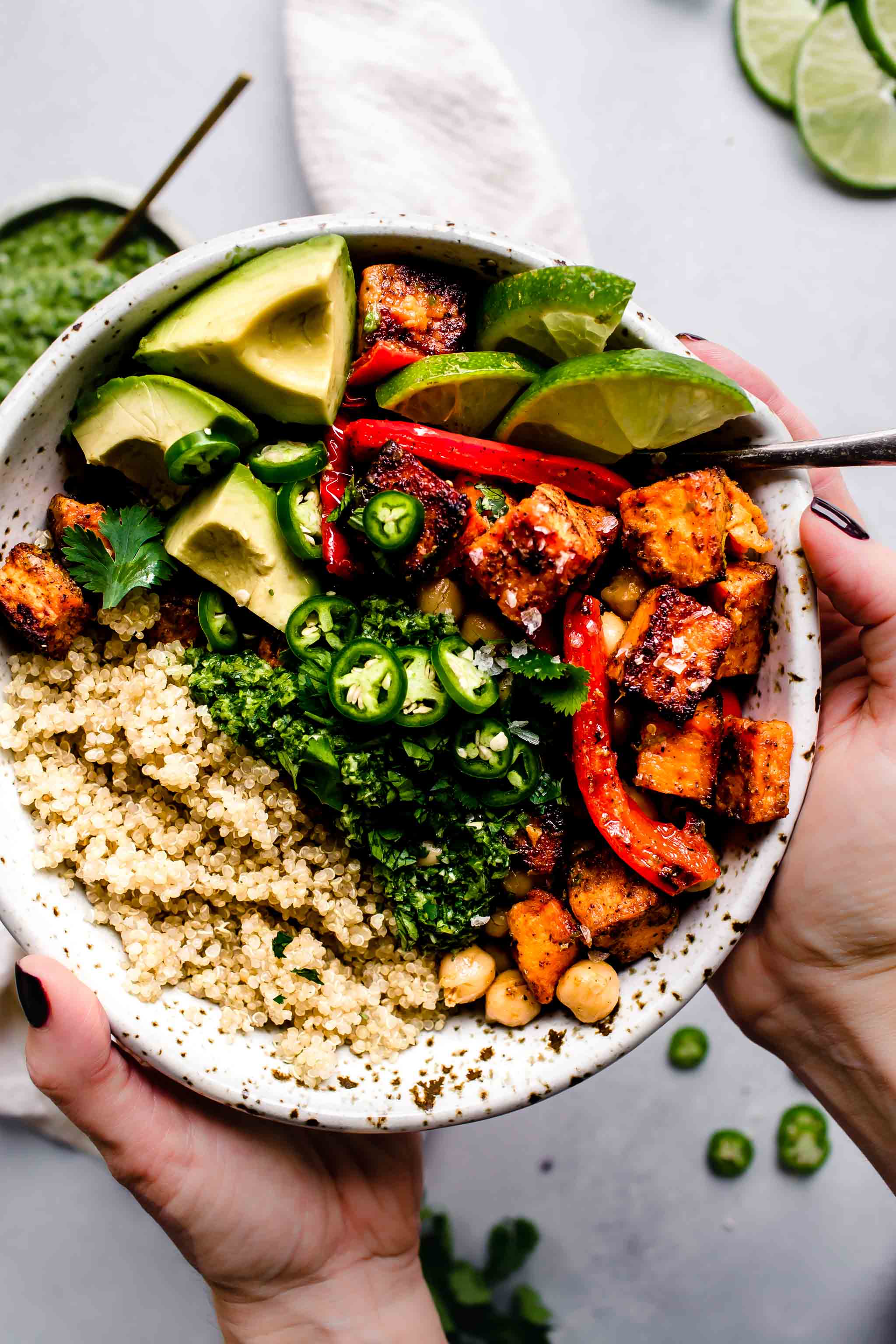 Two hands holding assembled buddha bowl.