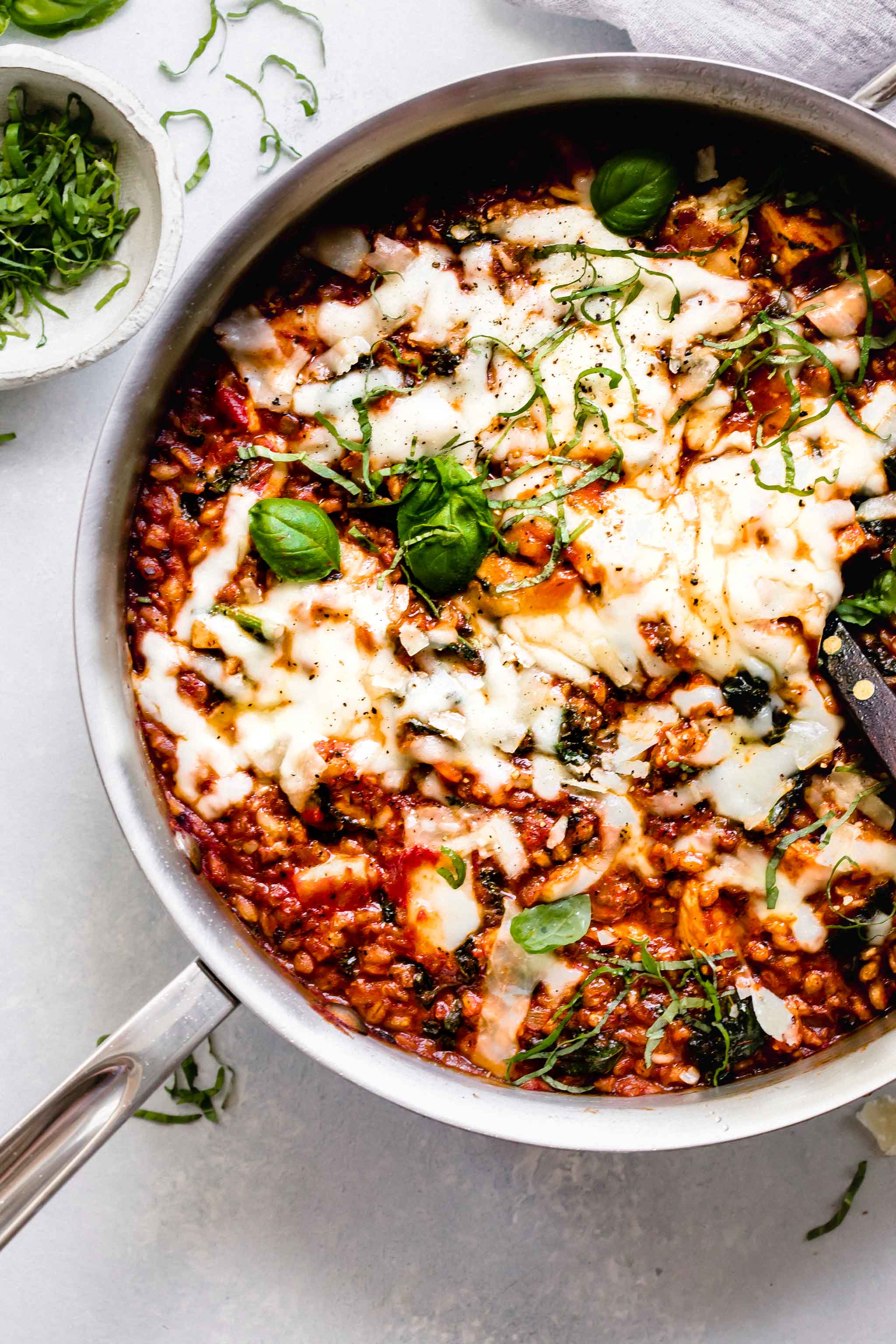 Overhead shot of farro skillet with chicken topped with melted cheese.