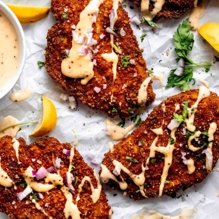 Overhead close up of pretzel crusted chicken drizzled with cheddar sauce.