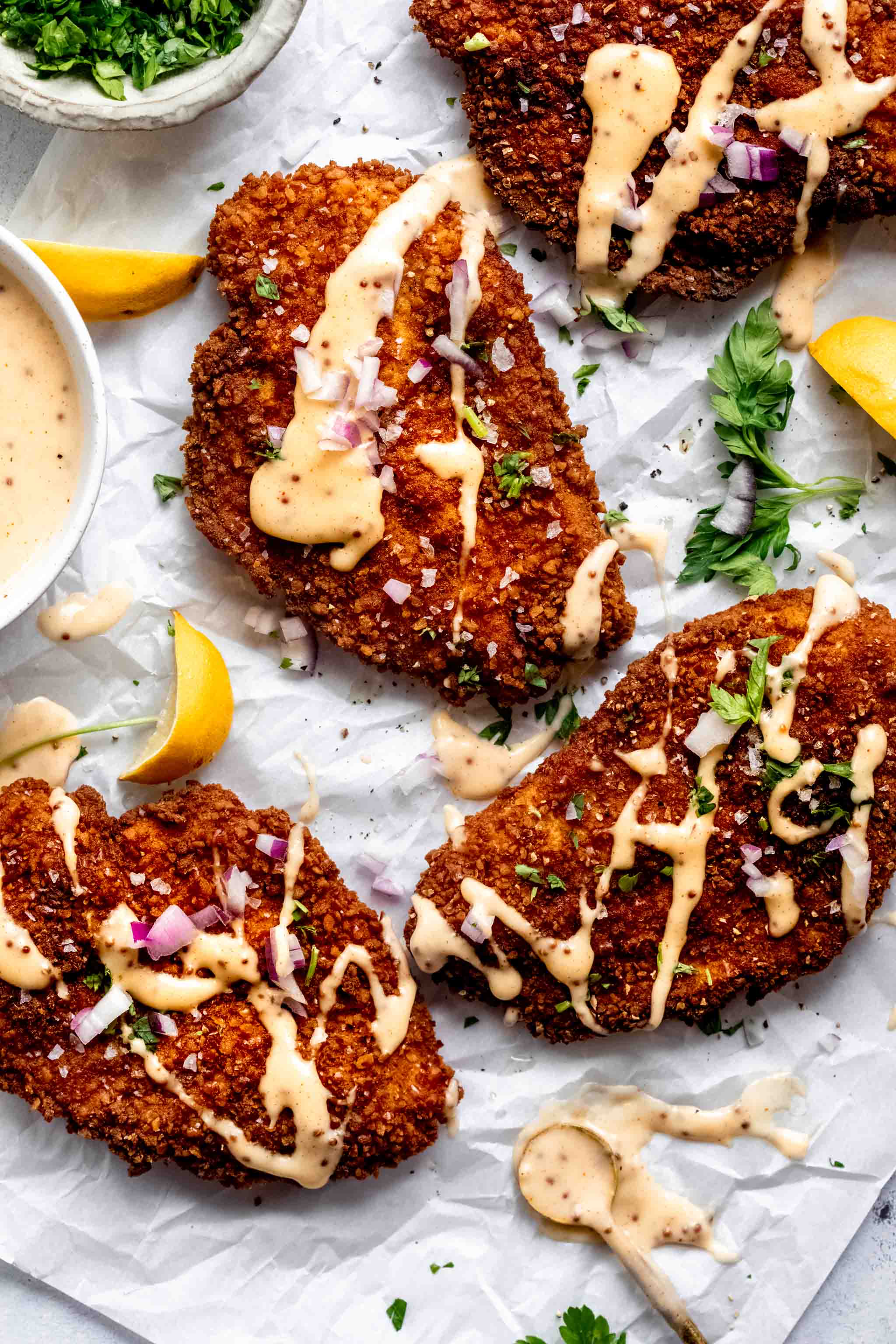 Overhead close up of pretzel crusted chicken drizzled with cheddar sauce.