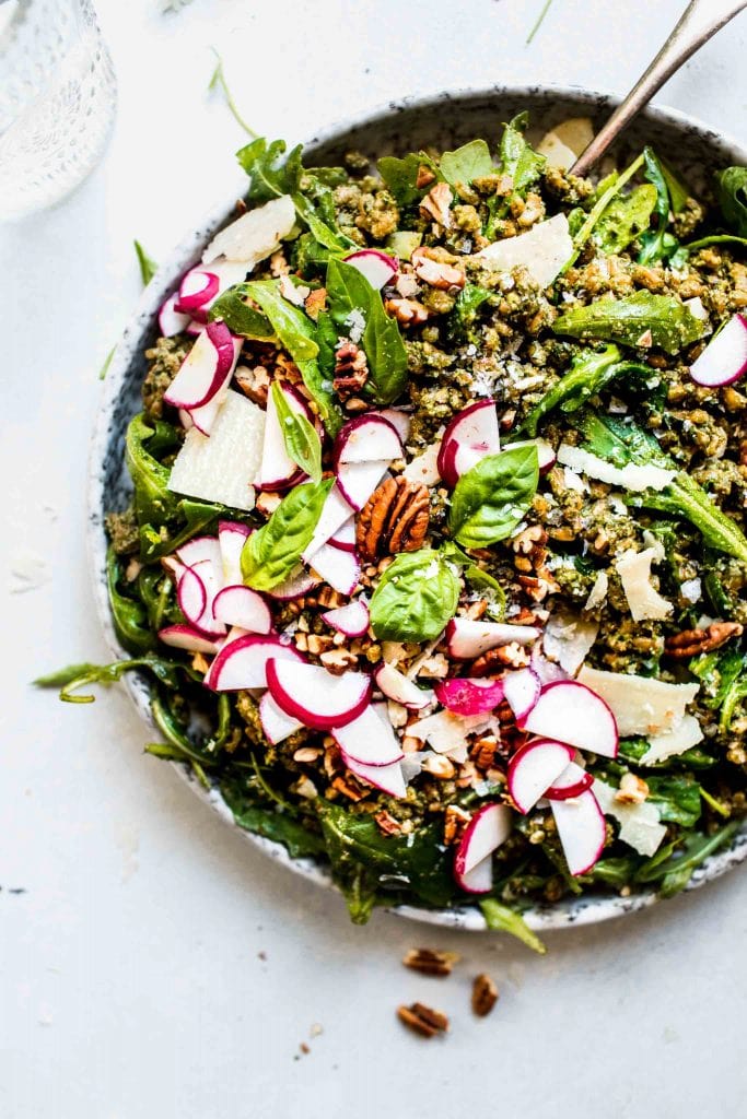 Pesto Farro Salad in bowl topped with radishes and pecans.