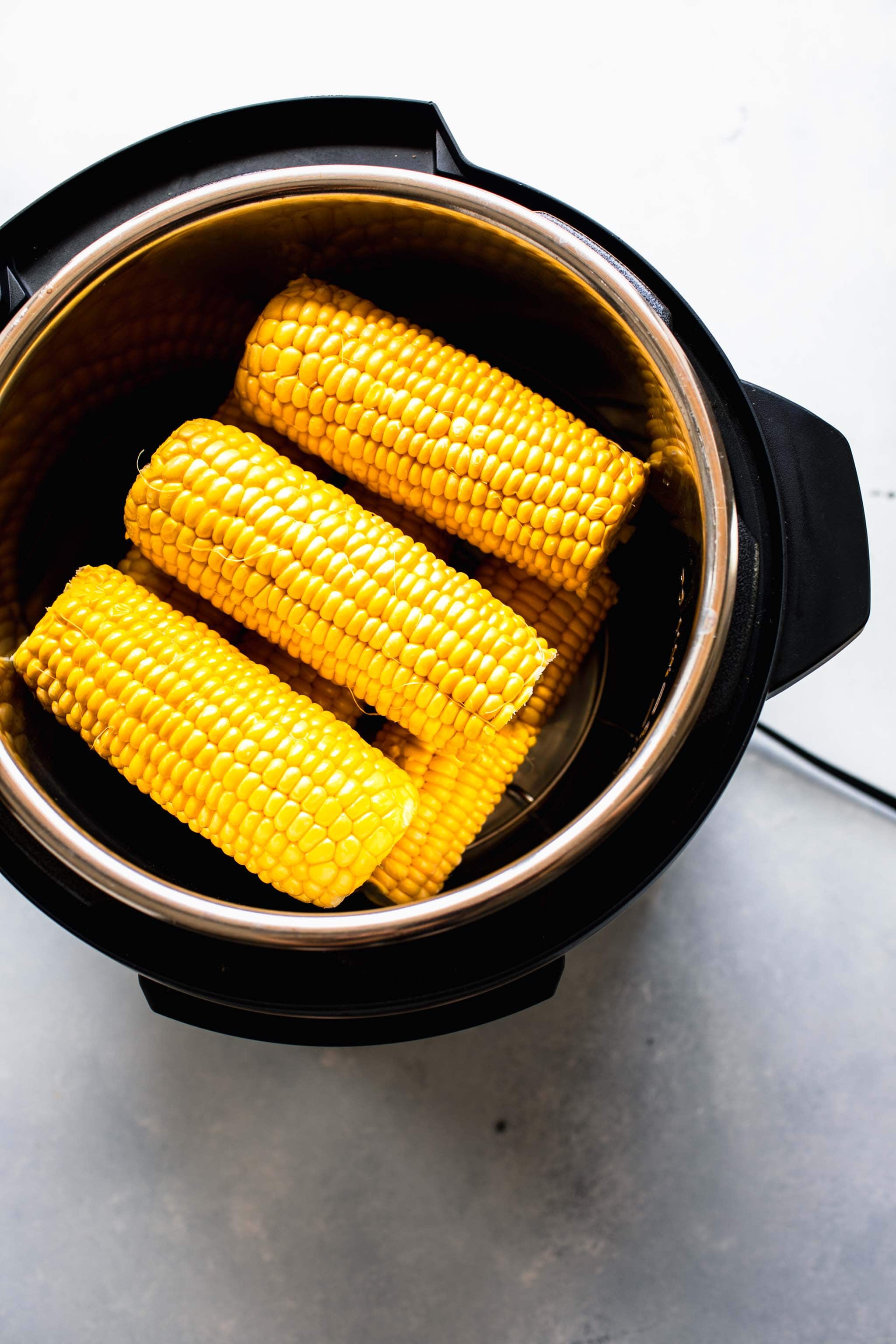 Uncooked ears of corn in the Instant Pot. 